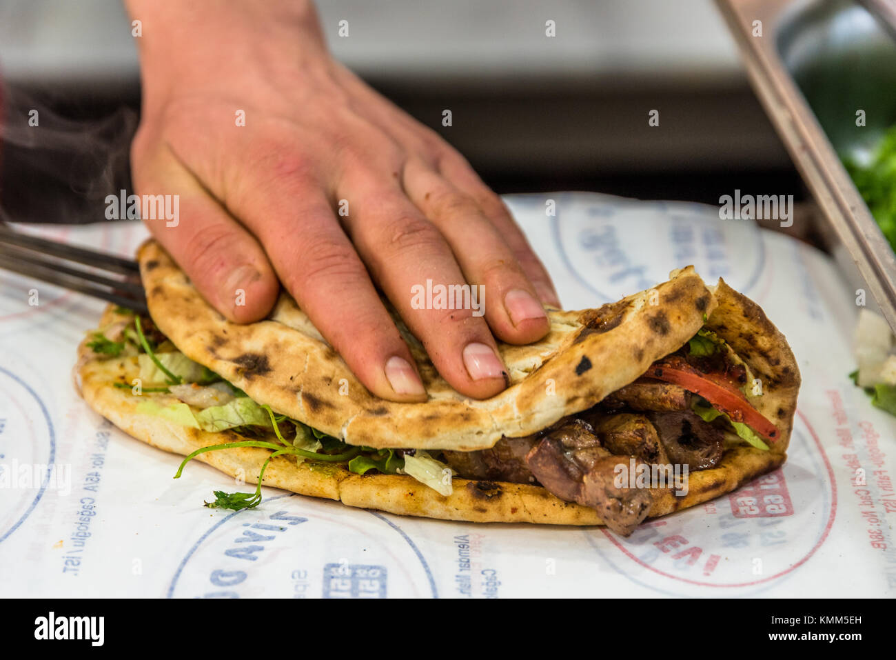 Man main préparer de délicieux grillés shish kebab turc du foie plus de servir. lavash Banque D'Images