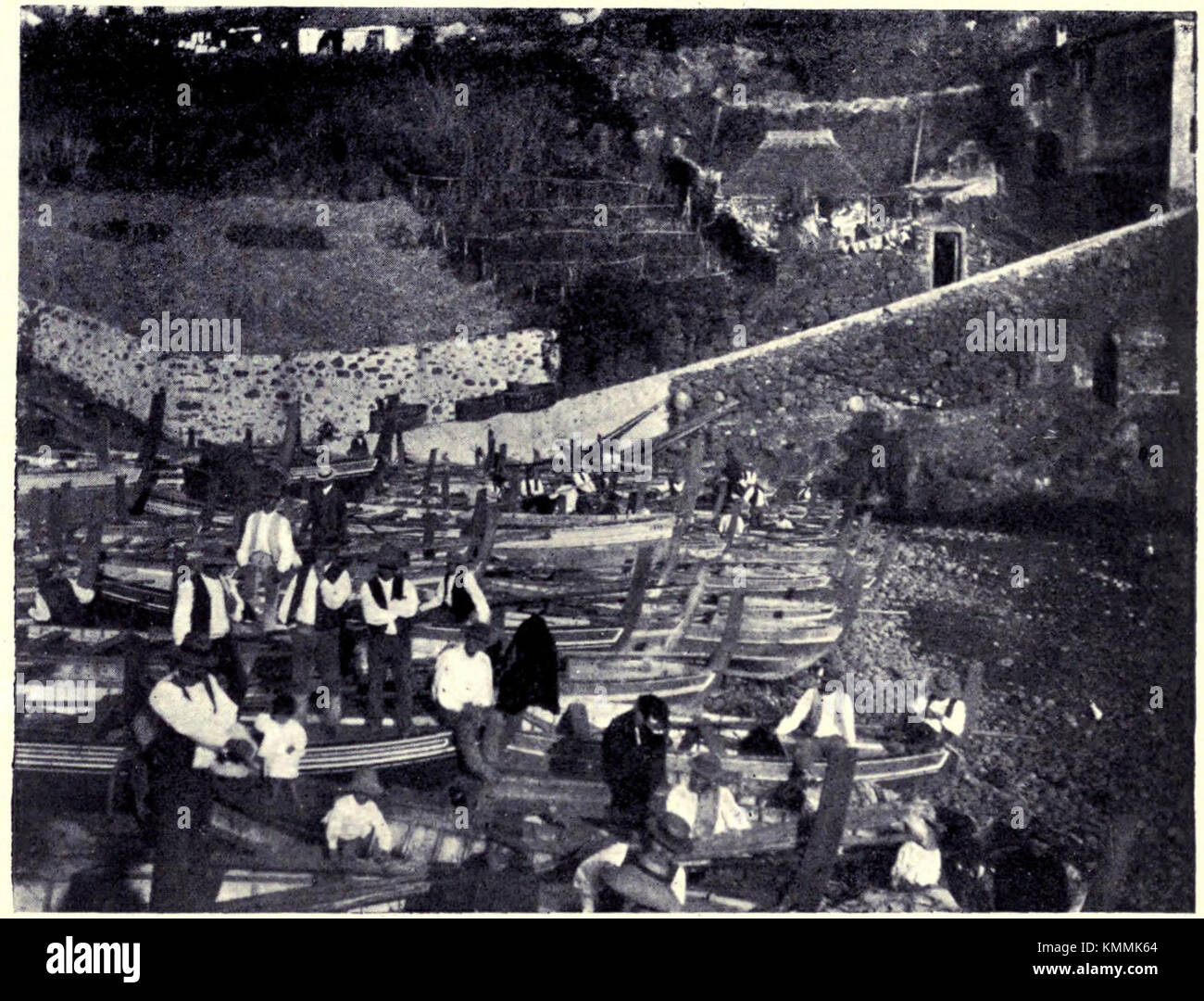 Image historique représentant des bateaux de pêche amarrés à la baie de Cama de Lobos à Madère, Portugal, à partir de 1909. La scène capture les méthodes de pêche traditionnelles et le paysage côtier de la région, avec des bateaux dans un cadre portuaire calme. Banque D'Images