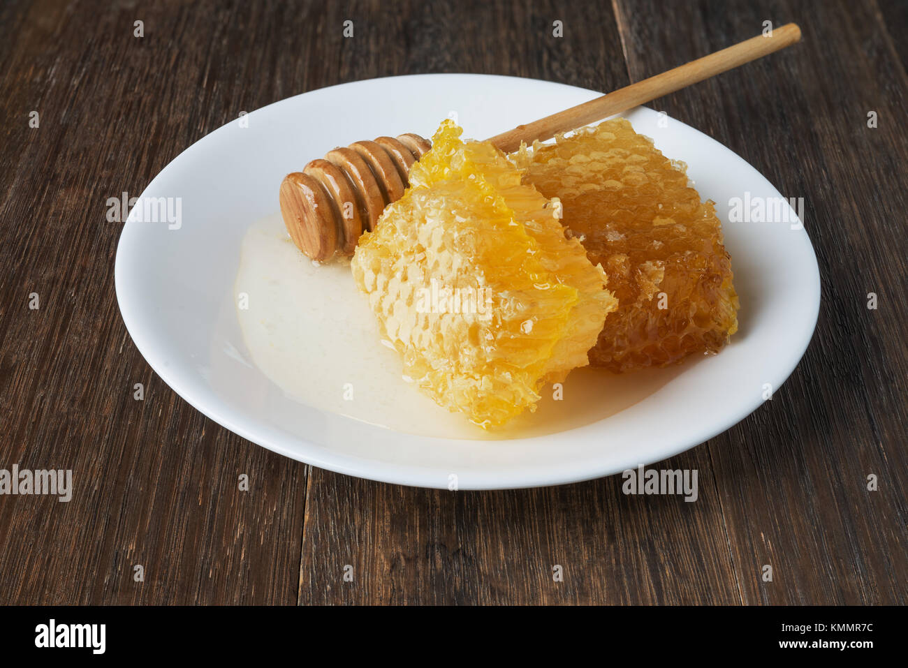 Nid d'or et de miel stick sur une plaque blanche sur table en bois vintage Banque D'Images
