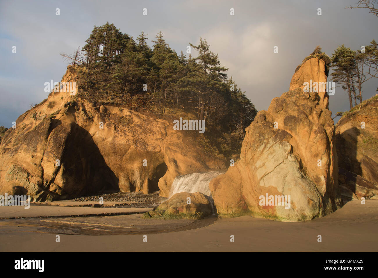 Cascade et rochers côtiers au crépuscule, parc d'état de hug point, Oregon Banque D'Images