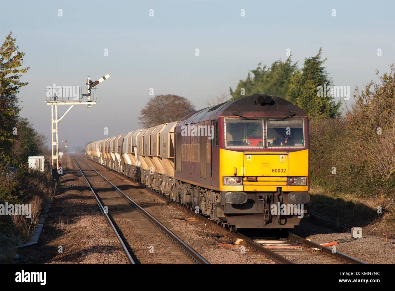Un certain nombre de locomotives diesel de catégorie 60 60002 un groupe de travail chargé de passage de pierre le sémaphore des signaux à Manea dans Cambridgeshire. Banque D'Images
