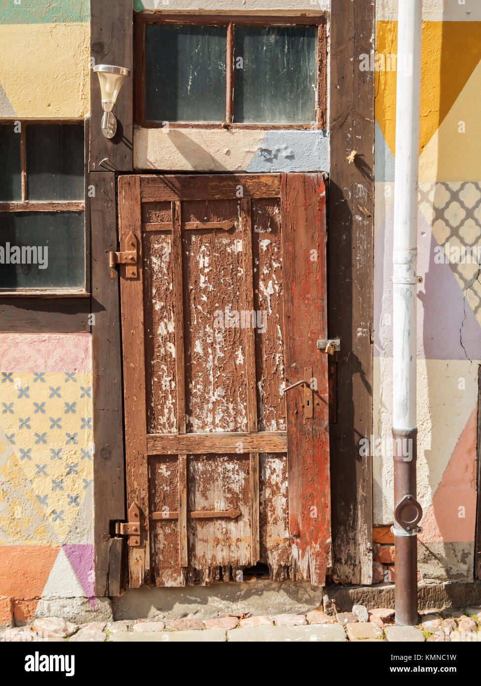 Old weathered wood porte à une ruine avec construction mur maison colorée. Banque D'Images