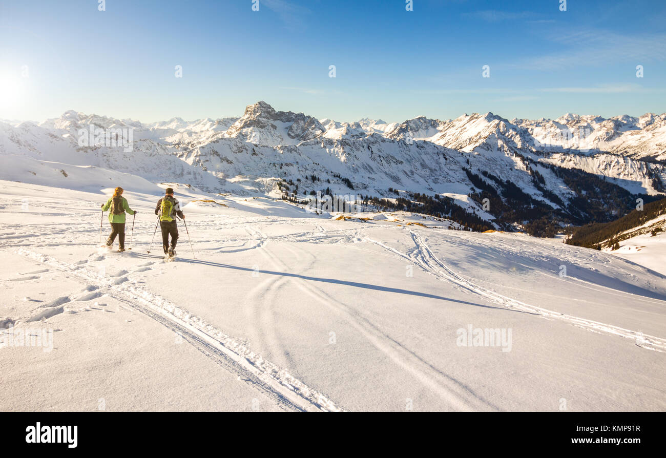 Deux randonneurs en raquettes au coucher du soleil dans les montagnes d'hiver des Alpes. La Bavière, Allemagne. Banque D'Images