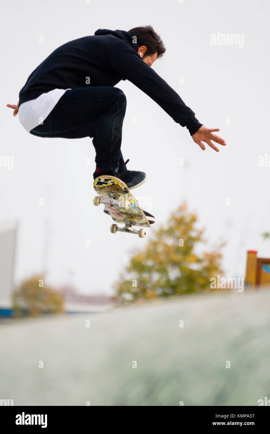 Un jeune garçon sautant avec skateboard------- GI, Imperia, ligurie, italie - le 26 octobre 2016 : un jeune garçon sautant sur la planche à roulettes dans un skatepark pendant Banque D'Images