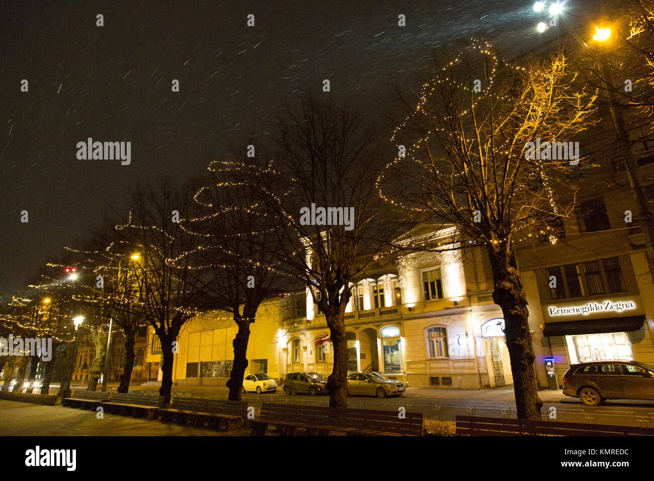 Les chutes de neige à nuit à Riga, Lettonie. Un arbres sont décorés avec des lumières de Noël. Banque D'Images