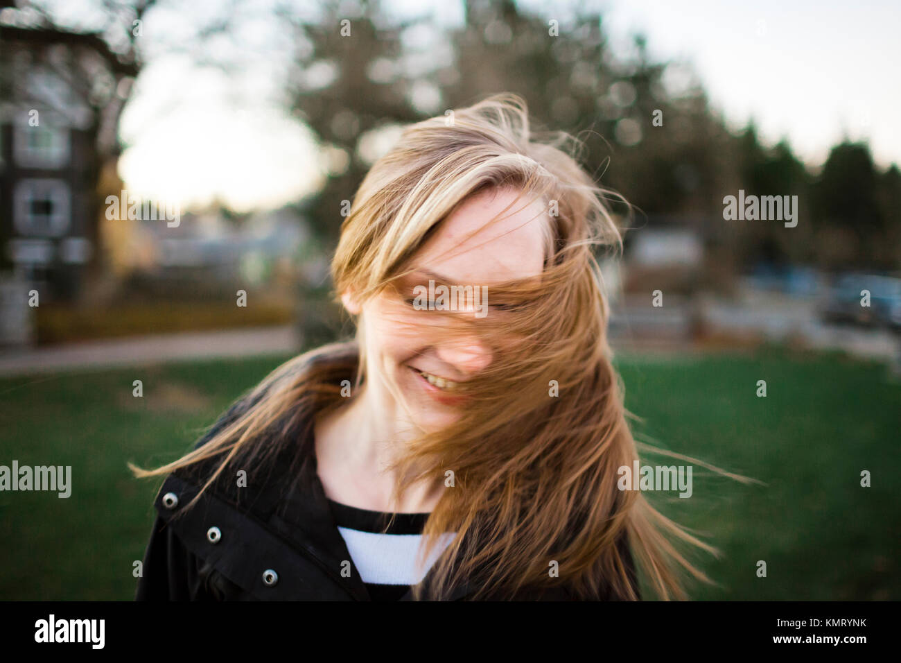 Cheerful woman tossing cheveux à park Banque D'Images