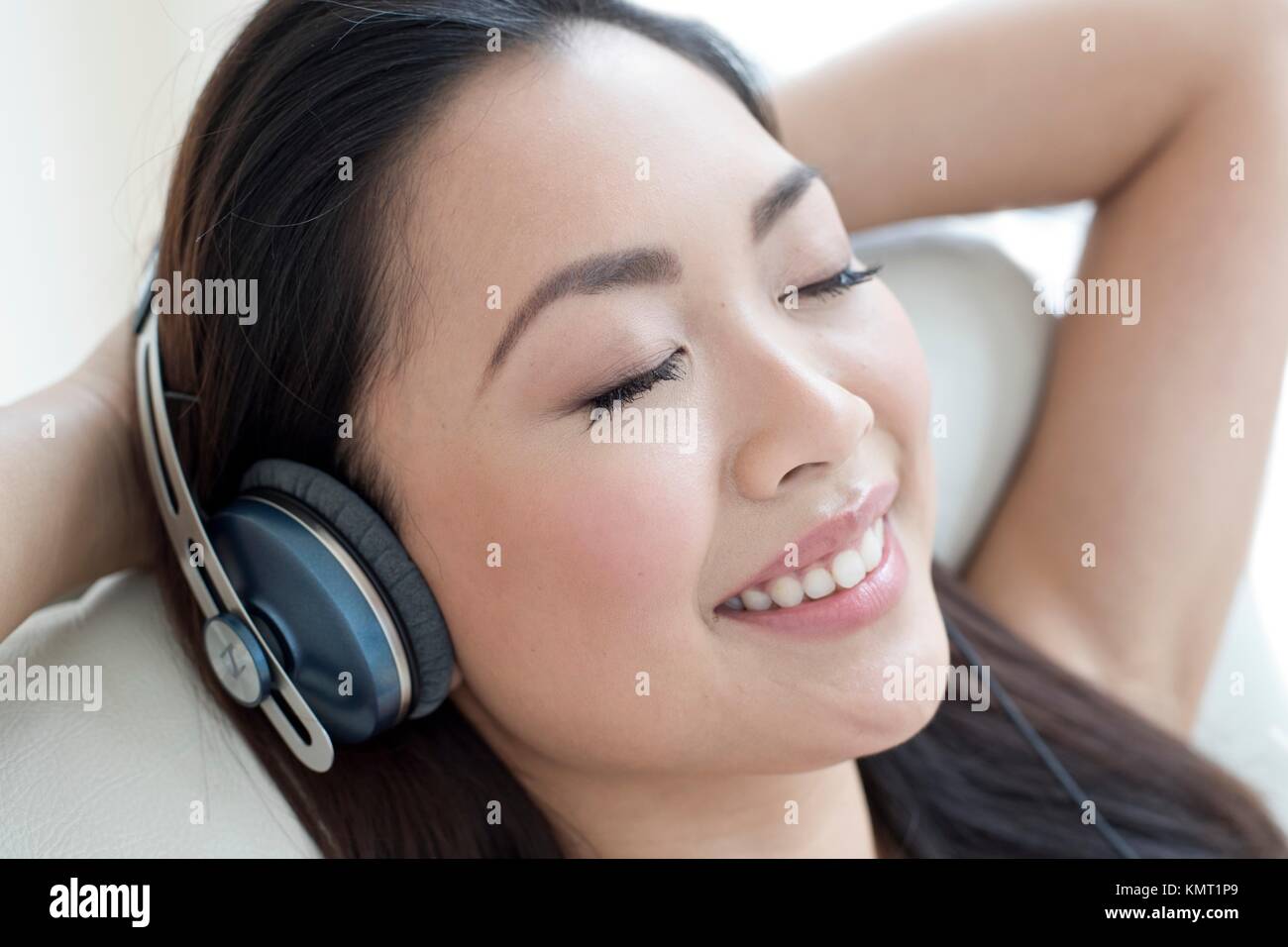 Young woman listening to music portant des écouteurs. Banque D'Images