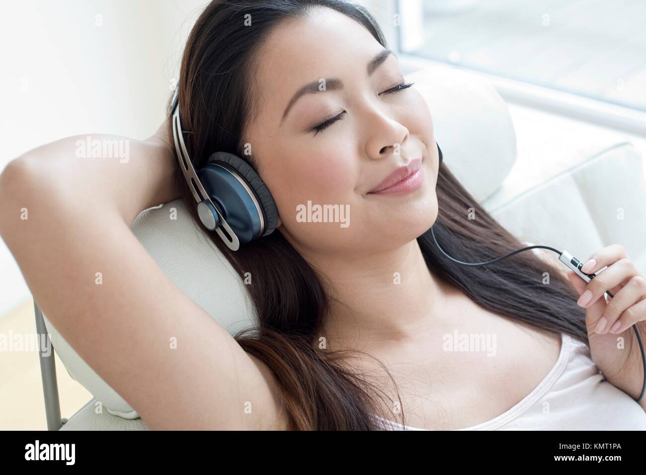 Young woman listening to music portant des écouteurs. Banque D'Images
