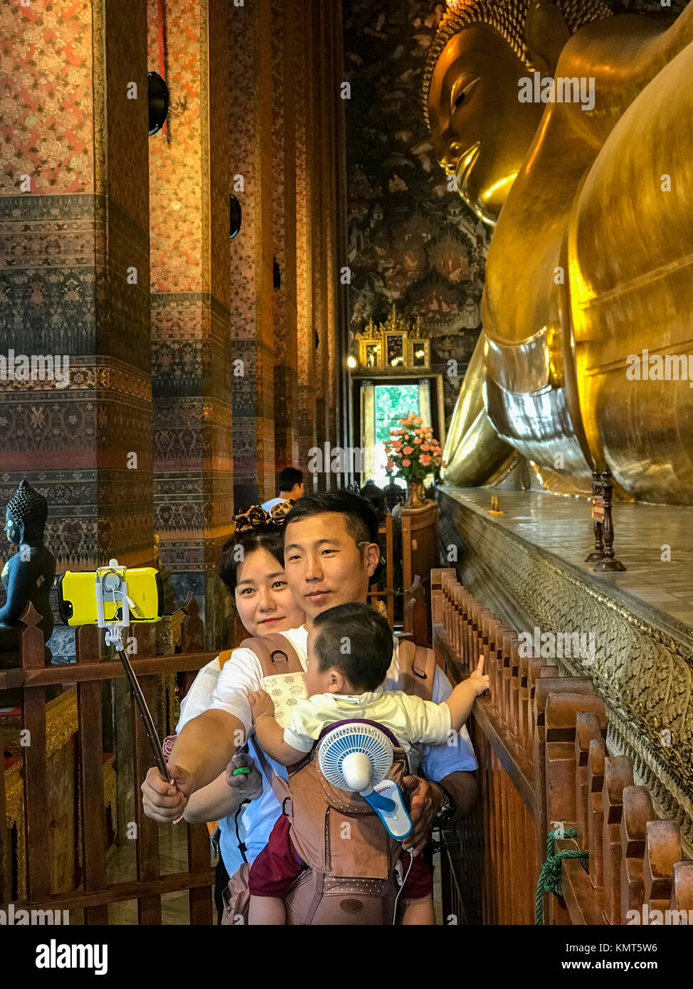 Bangkok, Thaïlande. Bouddha couché, Wat Pho temple complexe. Une jeune famille. Selfies Banque D'Images