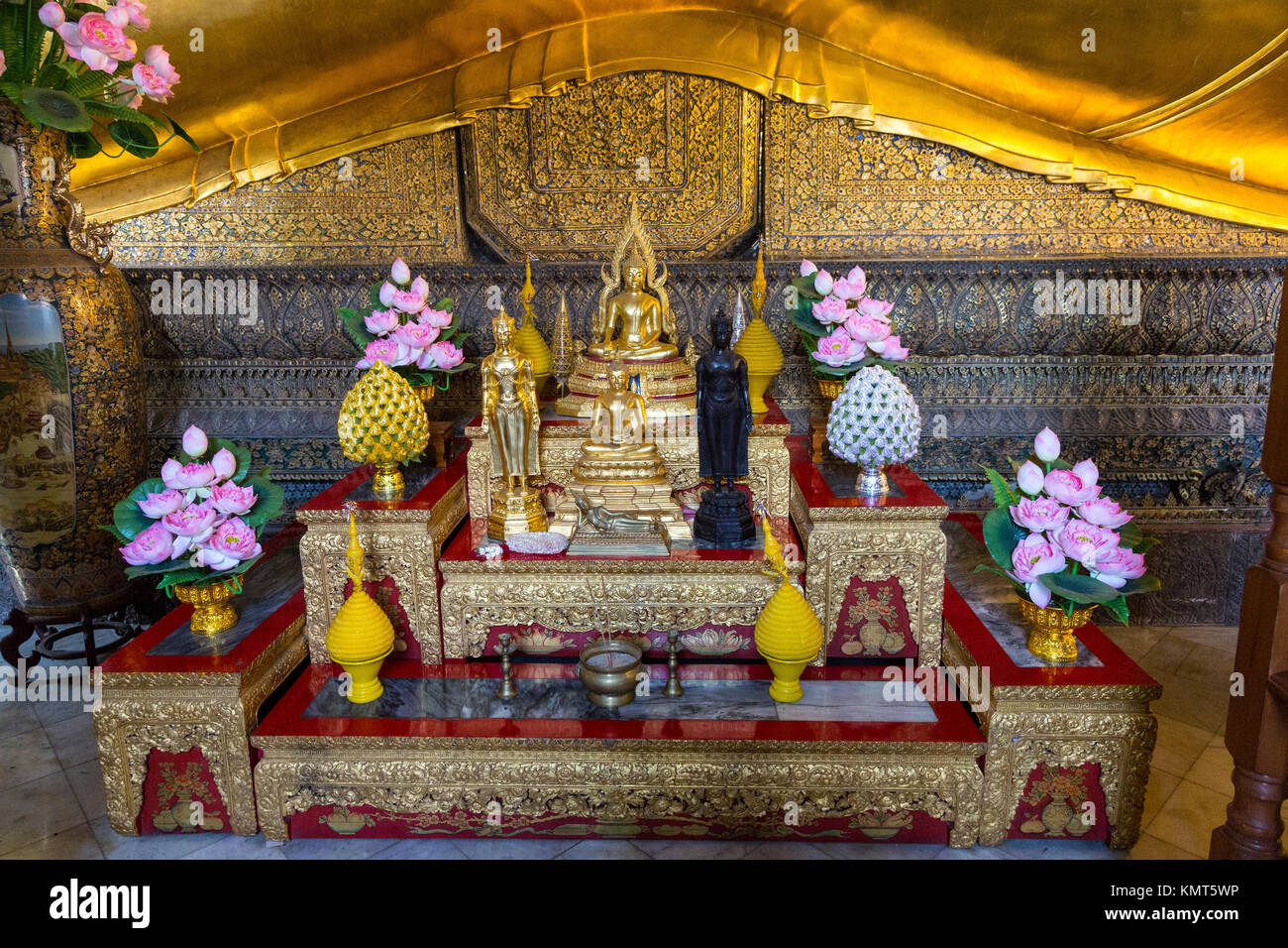 Bangkok, Thaïlande. Culte avec des fleurs de lotus au Bouddha couché, Wat Pho temple complexe. Banque D'Images