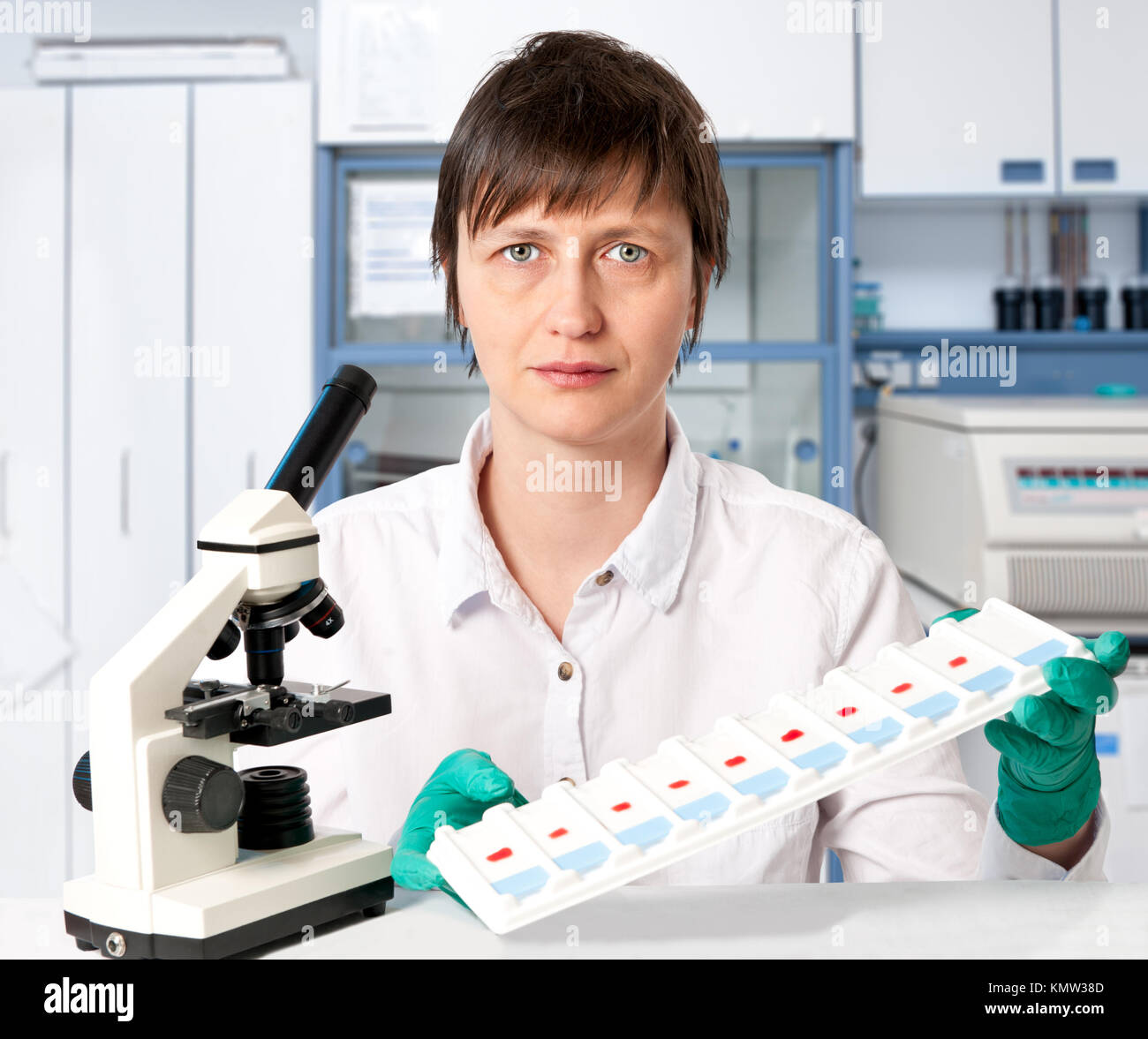 Histologiste avec un microscope et un bac de microscopiques sur un fond blanc Banque D'Images