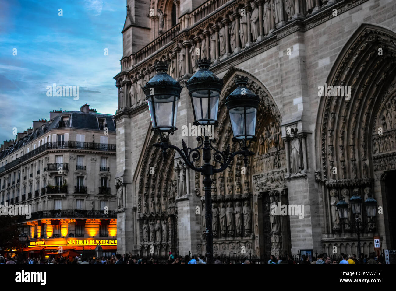 En début de soirée à l'extérieur de la Cathédrale Notre Dame de Paris France avec un ciel bleu, lampadaire et cafe lights Banque D'Images