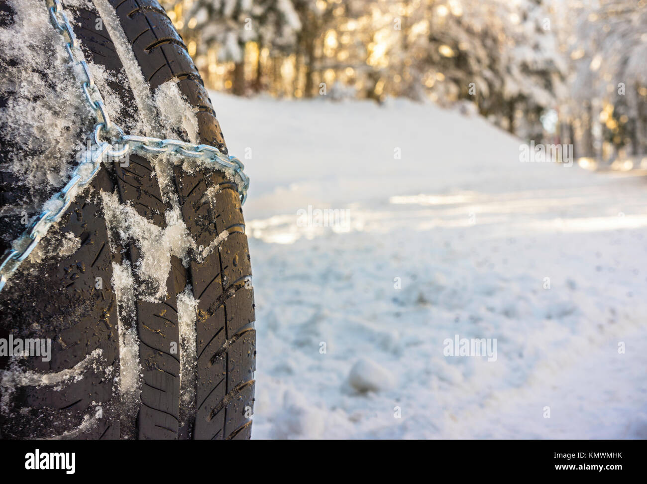 Libre de chaînes à neige montée sur une roue de voiture enneigée avec copie grand espace sur la gauche. Banque D'Images