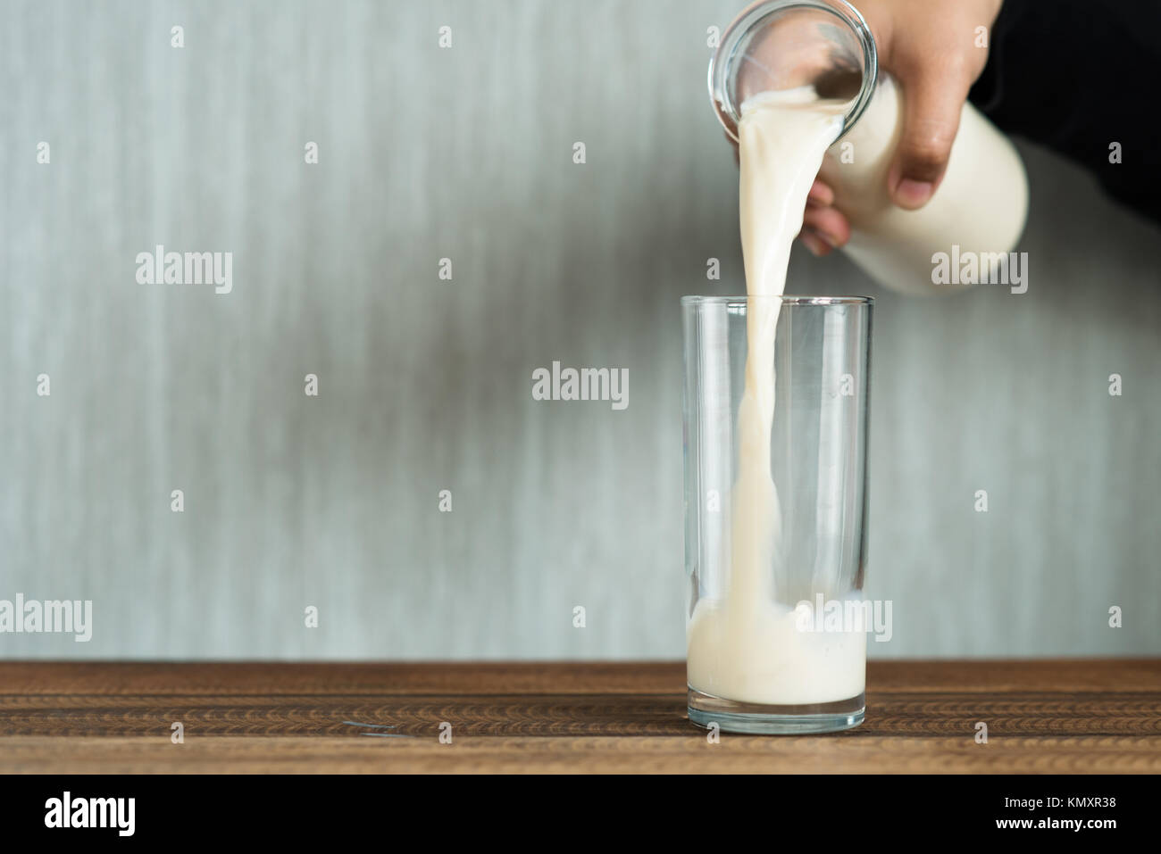 Verser le lait en verre. Le remplissage d'un verre de lait. Banque D'Images