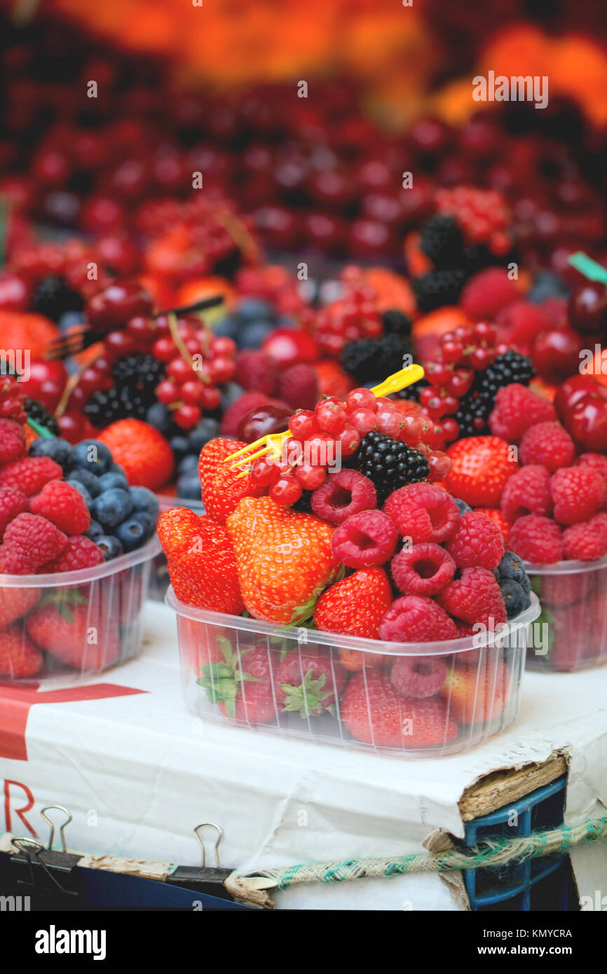 Mélange de fruits frais mûrs framboise, fraise, mûre et myrtille dans les boîtes en plastique jetable avec fourche de market Banque D'Images