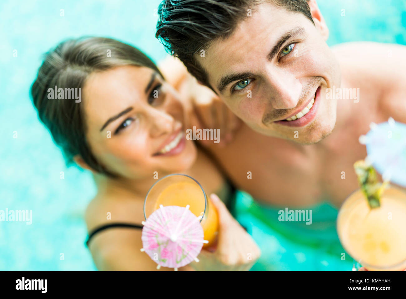 Portrait of a woman drinking a cocktail in a pool Banque D'Images