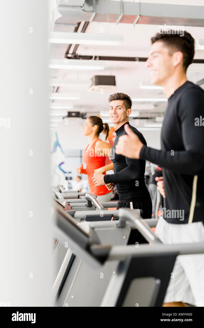 Groupe de jeunes à l'aide de tapis roulants dans une salle de sport Banque D'Images