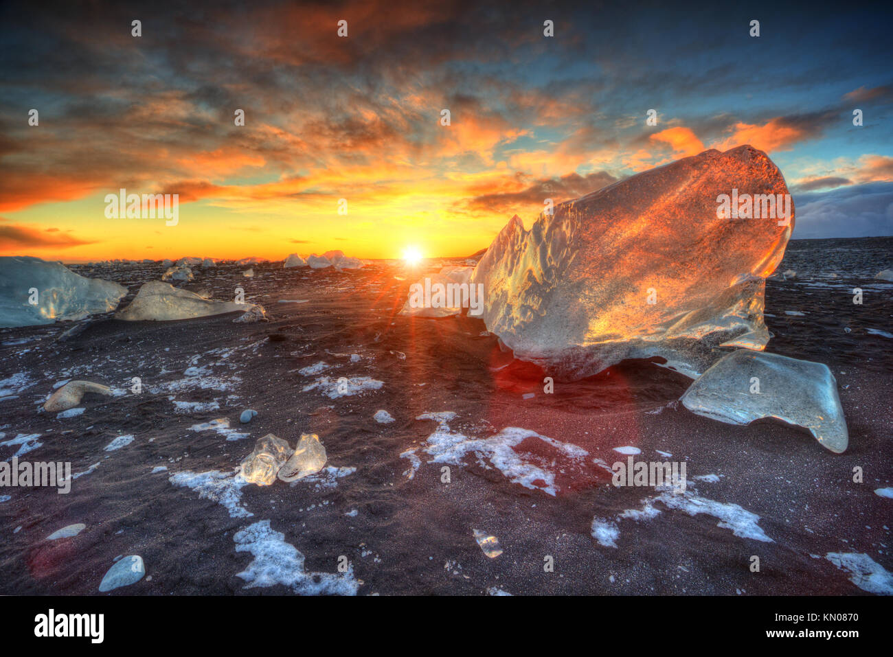 Magnifique coucher de soleil sur célèbre plage du diamant, de l'Islande. Cette lave sable plage est pleine de nombreux joyaux de glace géant, placé près de glacier Jökulsárlón lagon. Banque D'Images