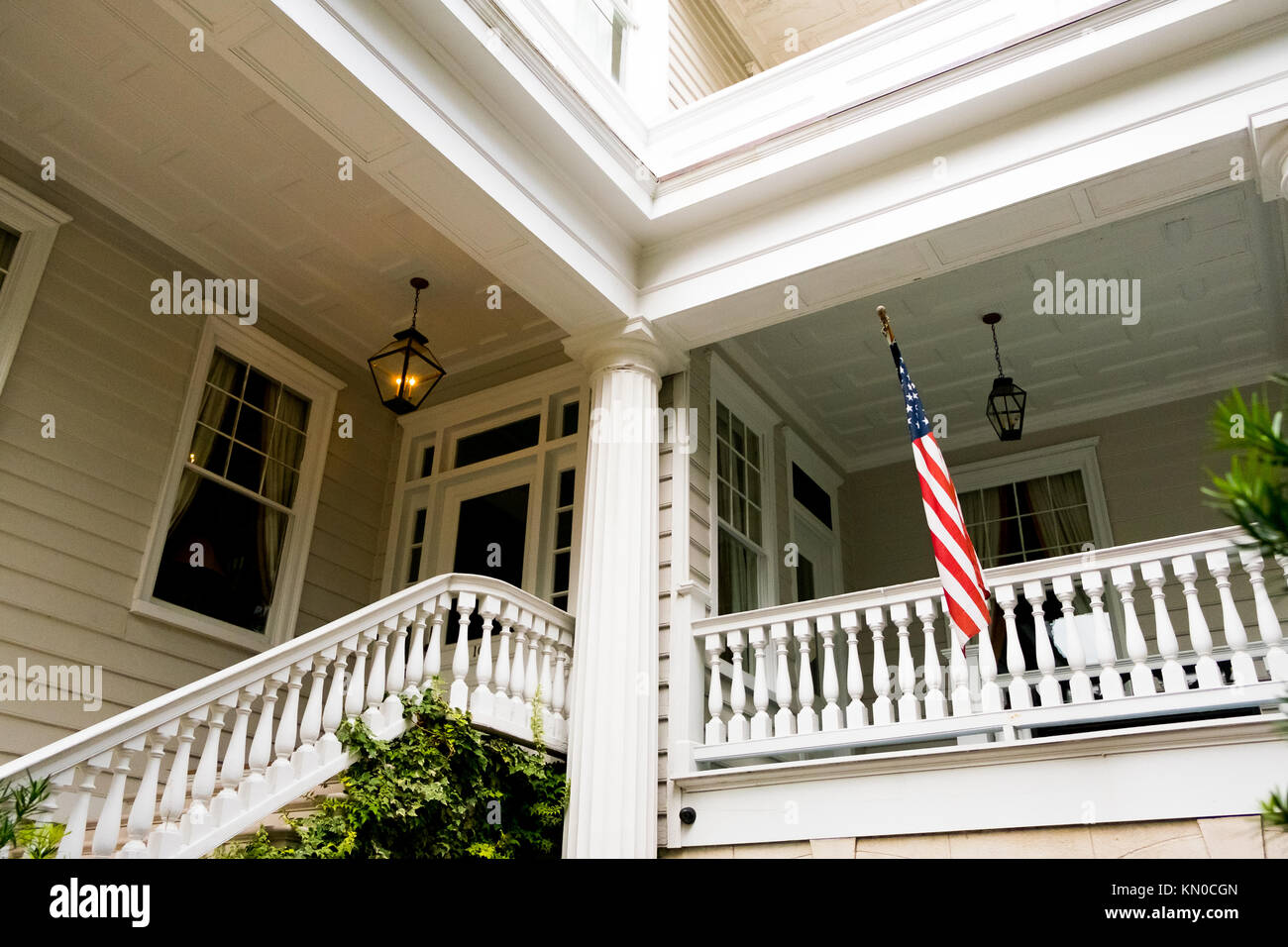 Maison de style colonial avec porche et drapeau américain Banque D'Images
