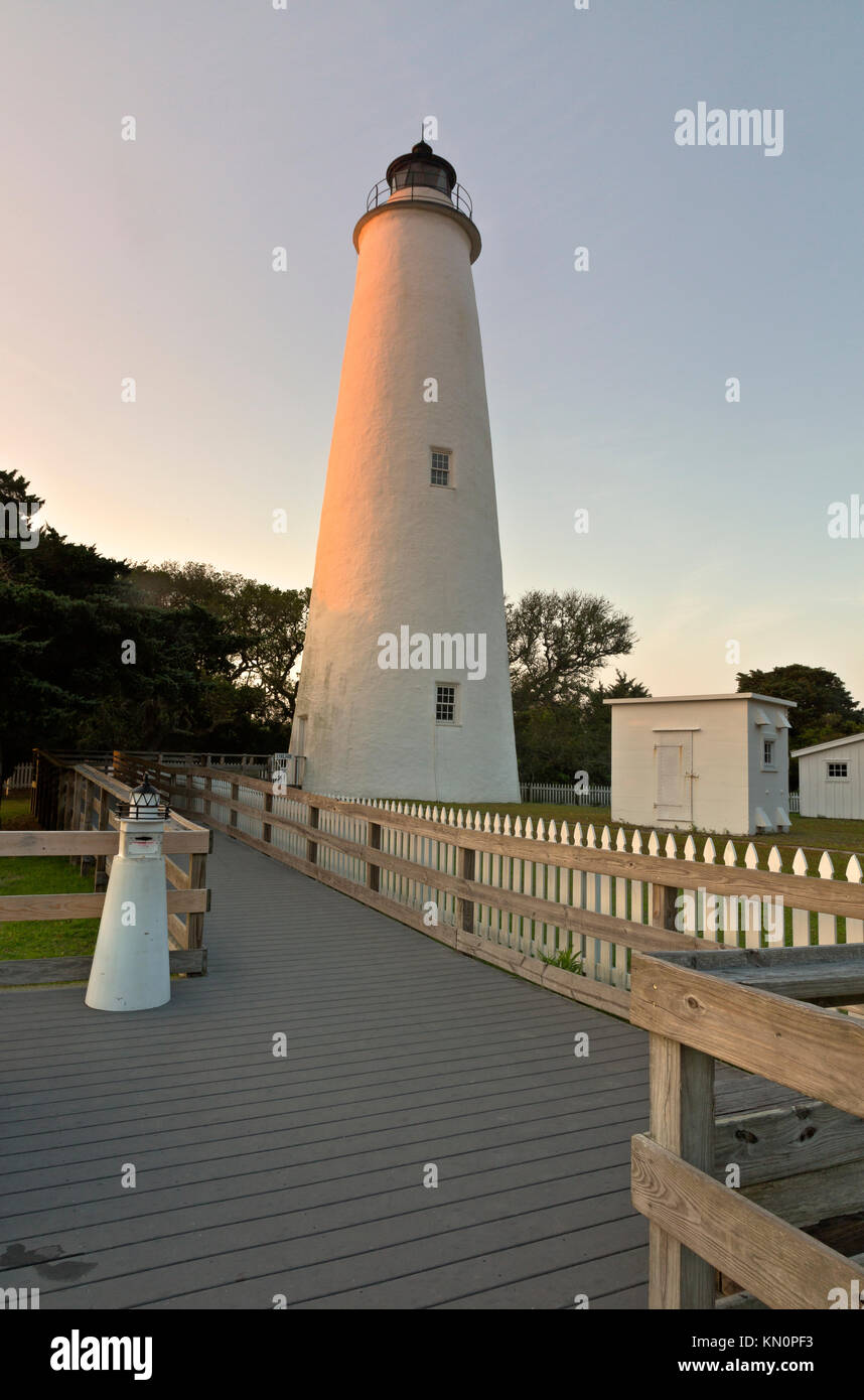 NC01034-00...CAROLINE DU NORD - promenade menant à la base d'Ocracoke Island phare au coucher du soleil sur les bancs extérieurs. Banque D'Images