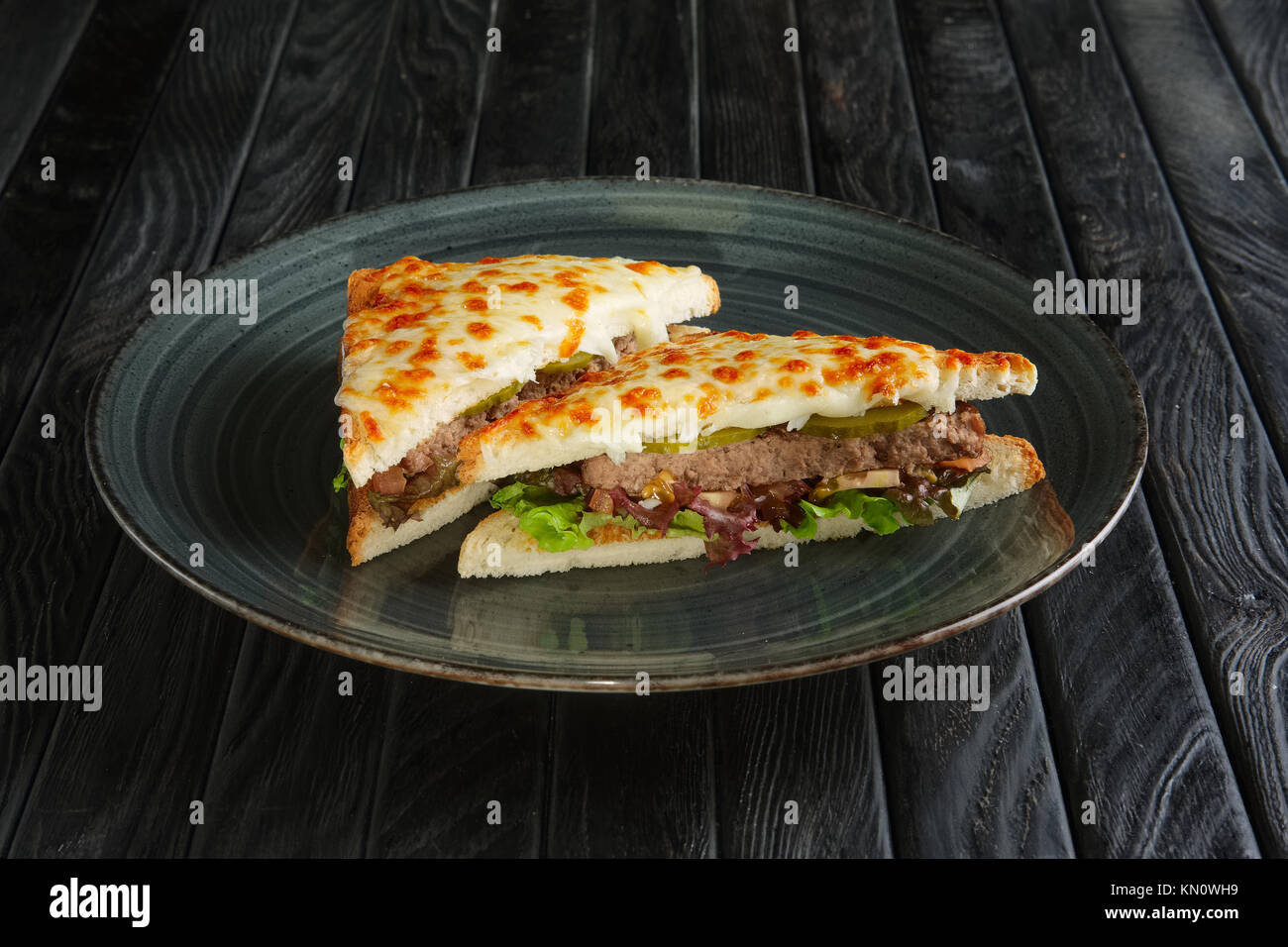Club sandwich avec de la viande, cornichon, salade et fromage fondu Banque D'Images