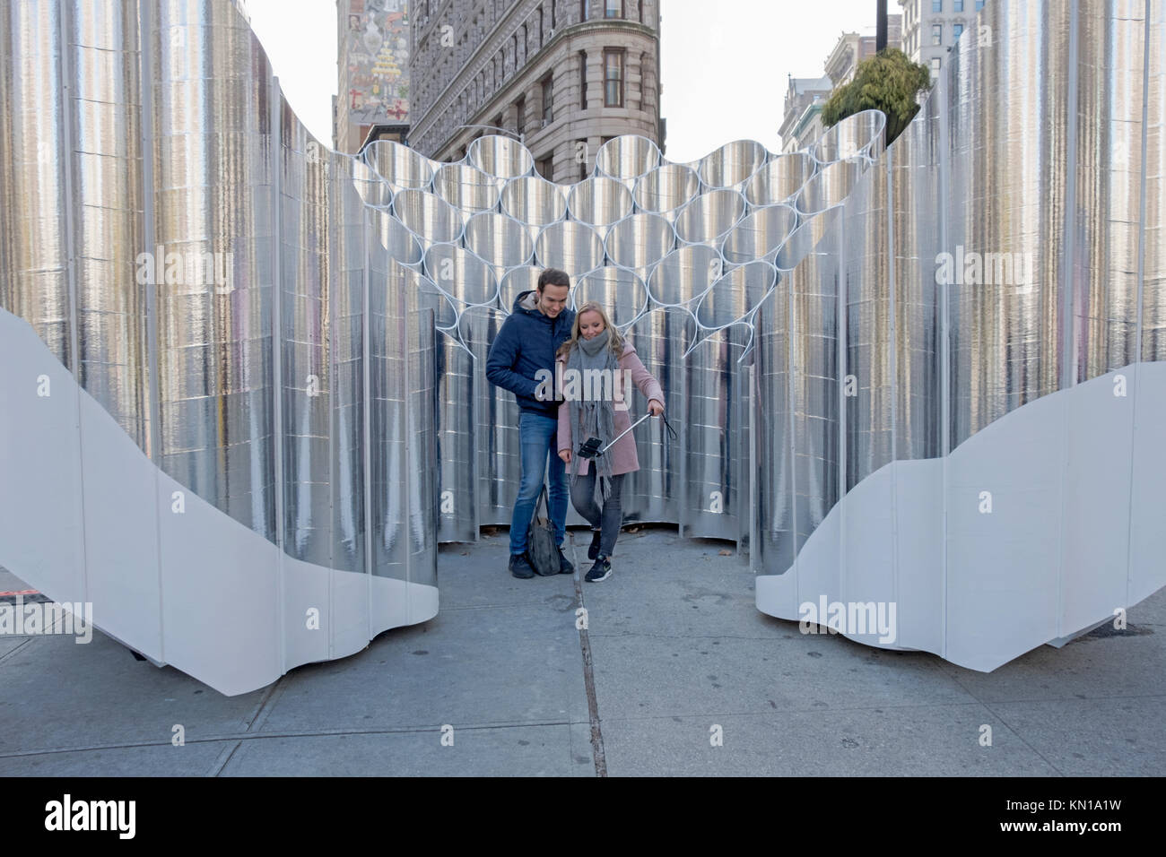 Les touristes allemands se faisant passer pour des photos en face de la sculpture des réflexions par Flatiron Expression future dans le quartier Flatiron de New York City. Banque D'Images