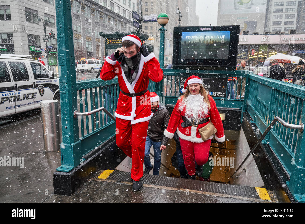 New York, États-Unis, 9 déc 2017. Les gens déguisés en père Noël sortir du passage inférieur sous une tempête de neige pour rejoindre une antacon "fête" foule rassemblement. Photo par Enrique Shore/Alamy Live News Banque D'Images