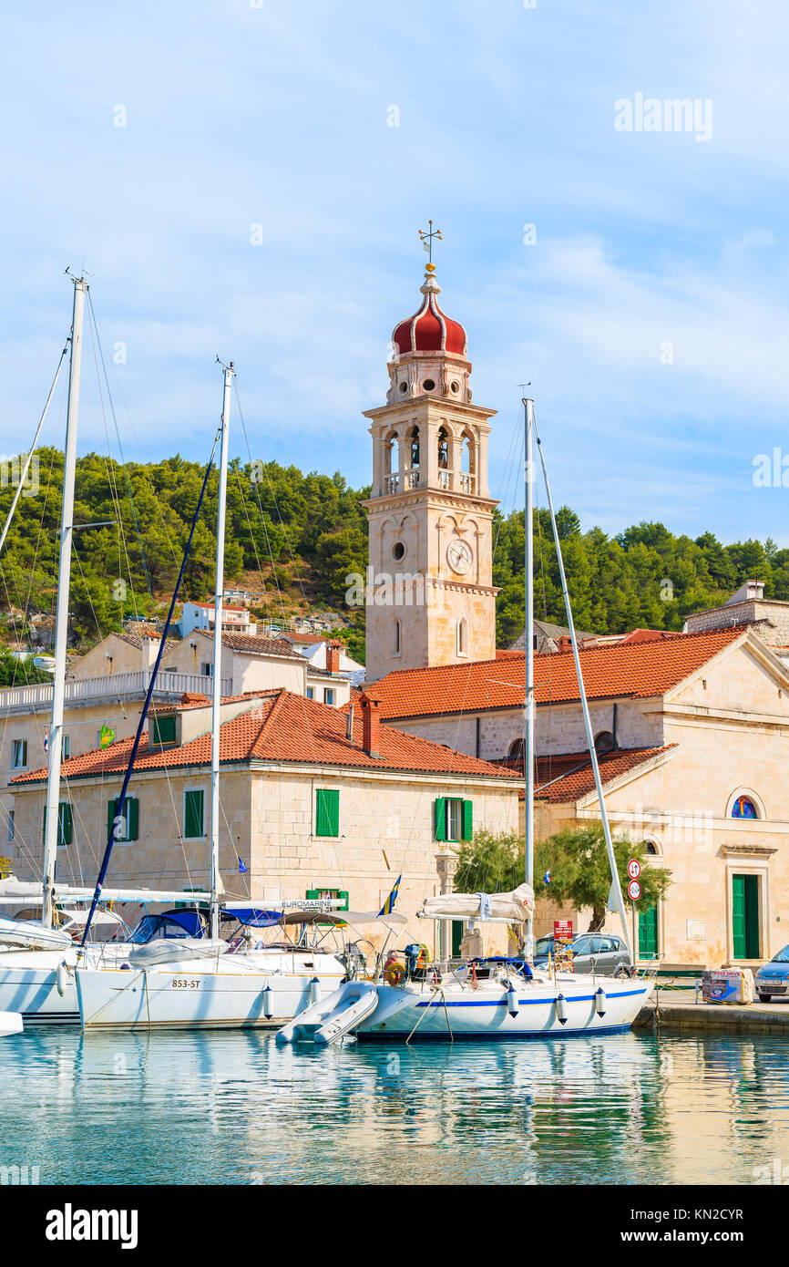 PORT DE SUPETAR, île de Brac - SEP 7, 2017 : Bateaux à voile s'ancrant dans Povlja port avec très belle église, île de Brac, Croatie. Banque D'Images