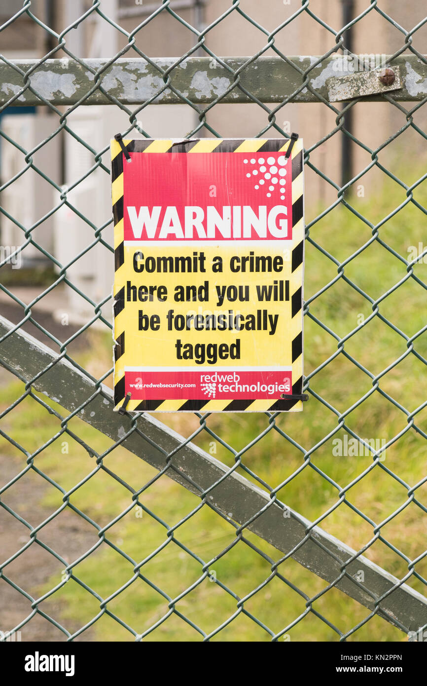 Panneau d'avertissement de marquage médico-légale sur la clôture de sécurité - commettre un crime ici et vous serez sur le plan contenant le tag - Édimbourg, Écosse, Royaume-Uni Banque D'Images