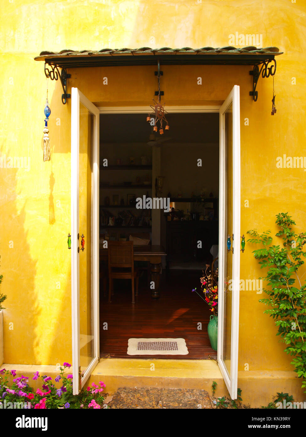 Maison Jaune mur avec porte ouverte et fleur Photo Stock - Alamy