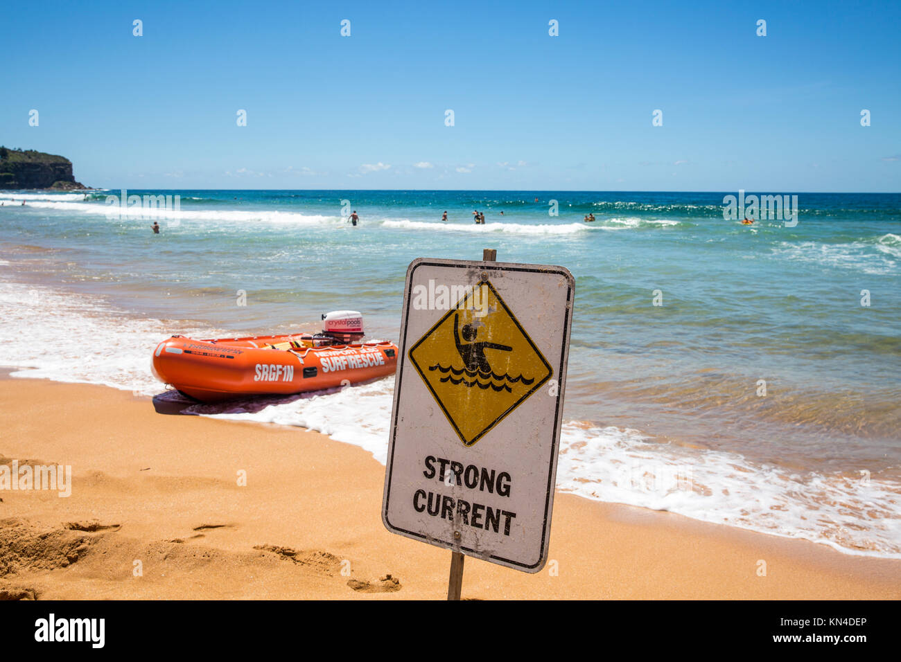 Panneau d'avertissement de courant fort à côté du canot de sauvetage IRB Sur Newport Beach sur Sydney Northern Beaches, Australie Banque D'Images