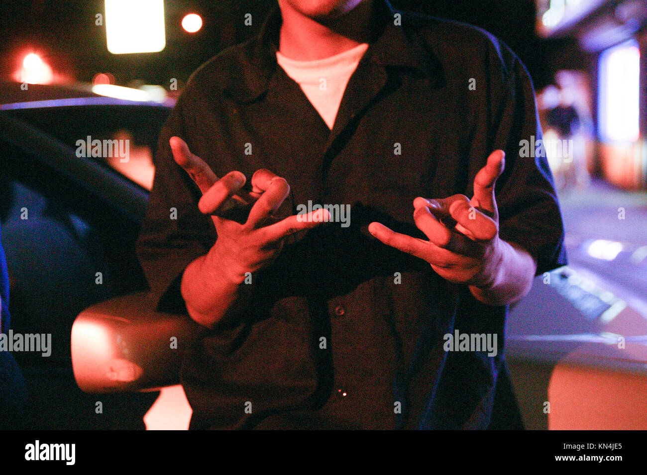 Un membre de gang possible 13 Mara Salvatrucha ou MS-13, fait un signe Mara Salvatrucha tandis que le comté de Suffolk contrôle de police pour les papiers d'identité à Brentwood, New York. De nombreux membres de la MS-13 sont aux États-Unis illégalement avec de faux documents. Banque D'Images