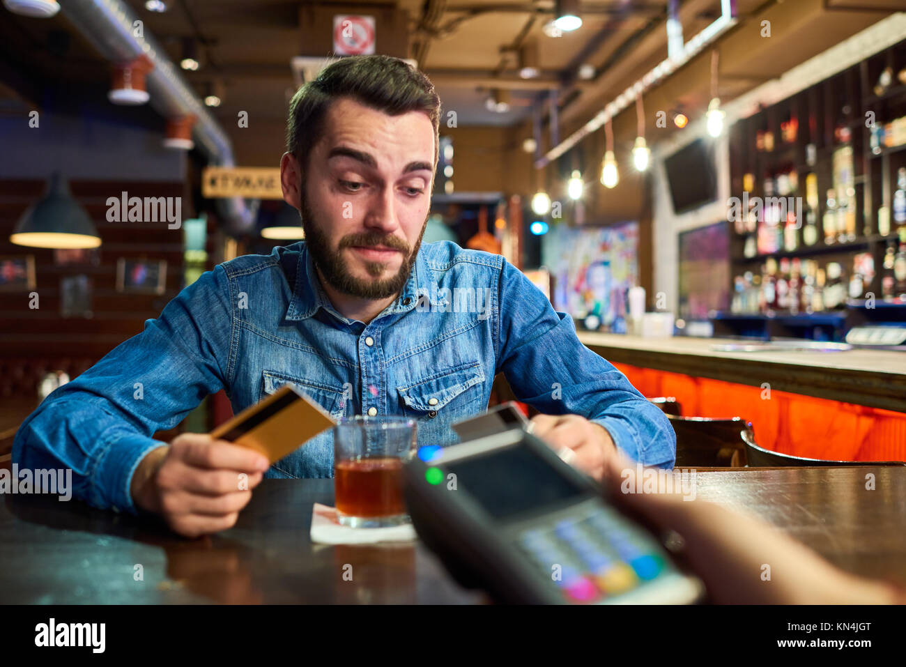 L'homme ivre de payer par carte de crédit dans un pub Photo Stock - Alamy