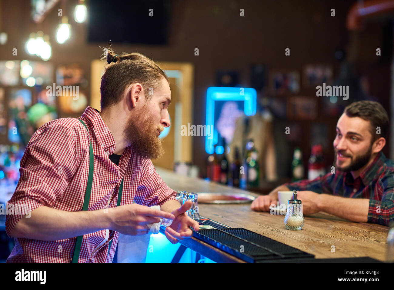 Barman parlant à visiteur au compteur Pub Banque D'Images