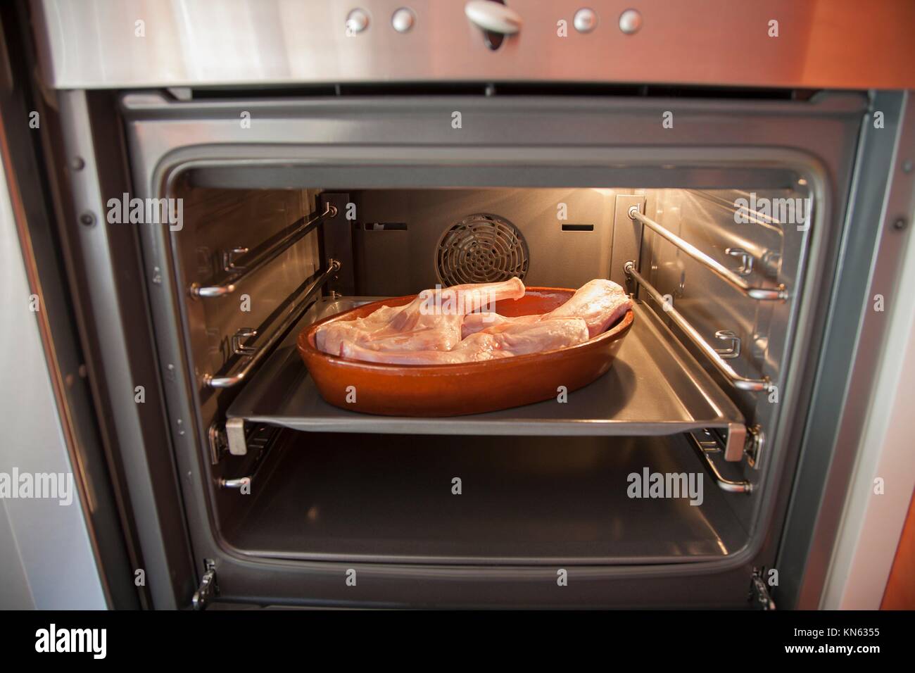 L'espagnol matières gigot d'agneau pour bébé dans le bac en céramique brun  prêt à rôtir dans un four Photo Stock - Alamy