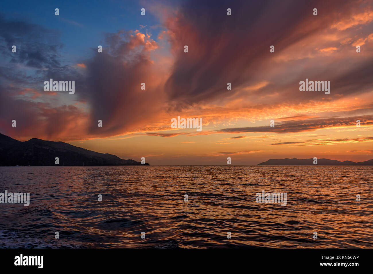 Coucher du soleil doré sur la mer après la tempête avec des nuages sombres Banque D'Images