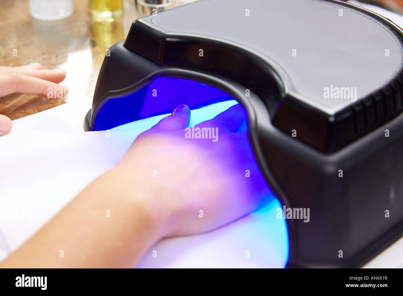 Peinture des ongles avec lampe UV en lumière bleue dry femme mains à salon  de manucure Photo Stock - Alamy
