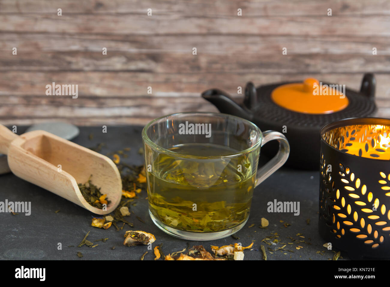 Dans la tasse de thé vert chaud composition avec bougie et pot de thé Banque D'Images