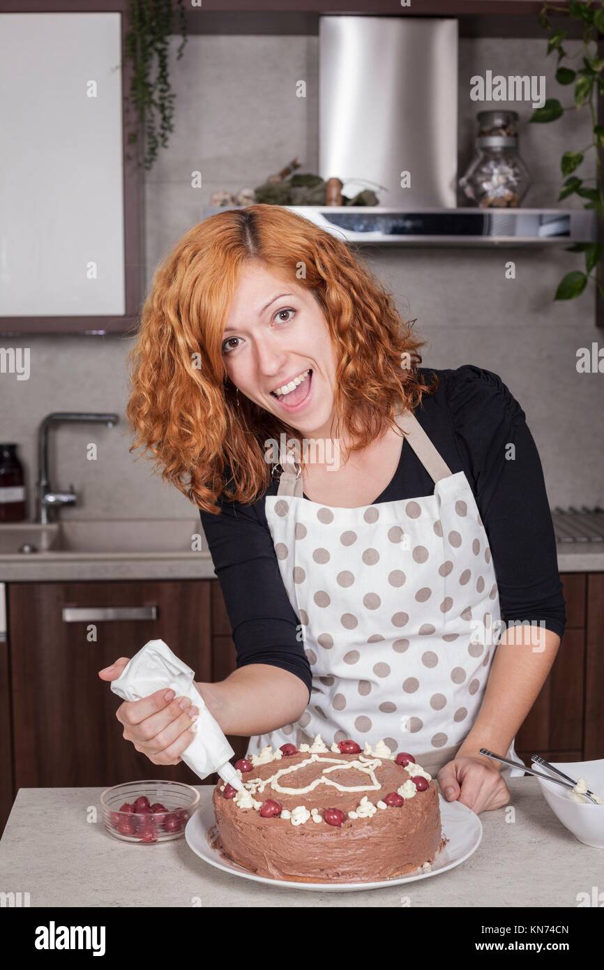 Femme Rousse Excite La Decoration De Gateau Au Chocolat Avec Un Coeur D Amour Dans La Cuisine A La Maison Photo Stock Alamy