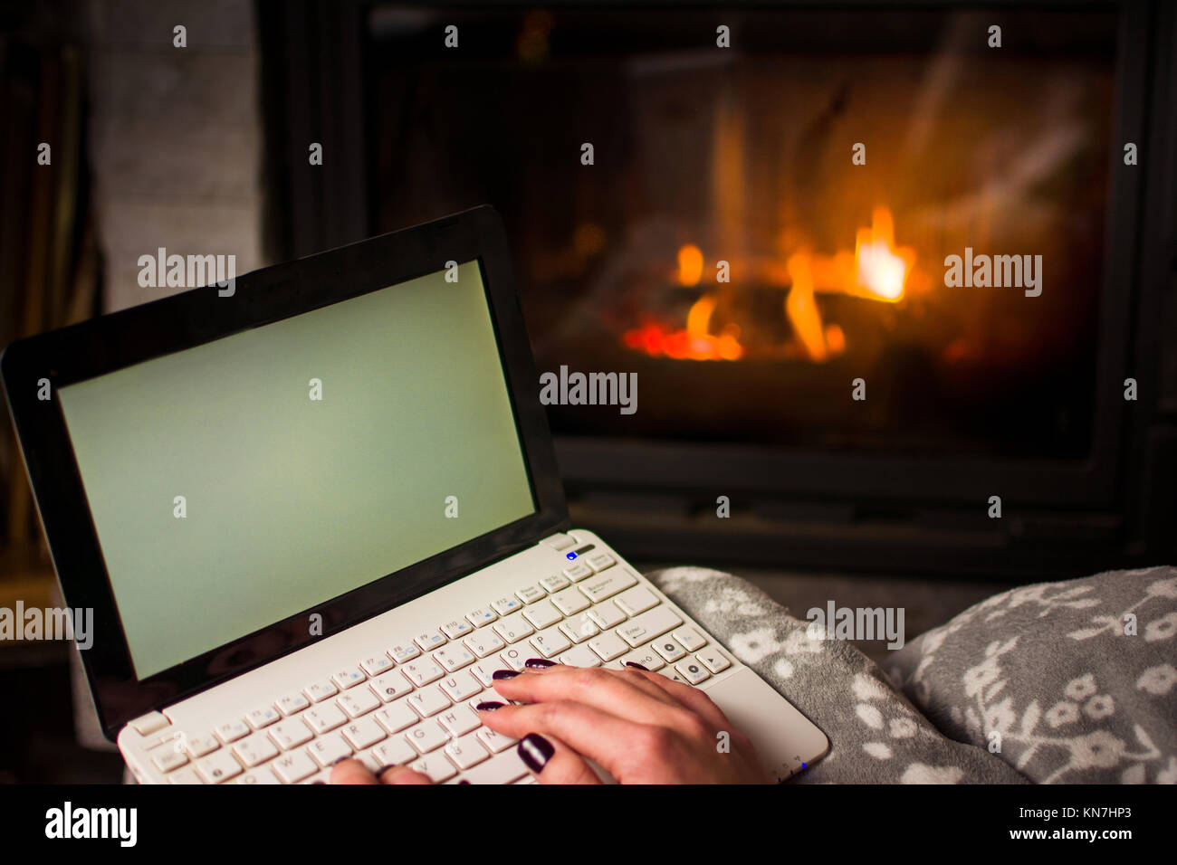 Girl using laptop par la cheminée. Vie d'hiver douillet Banque D'Images