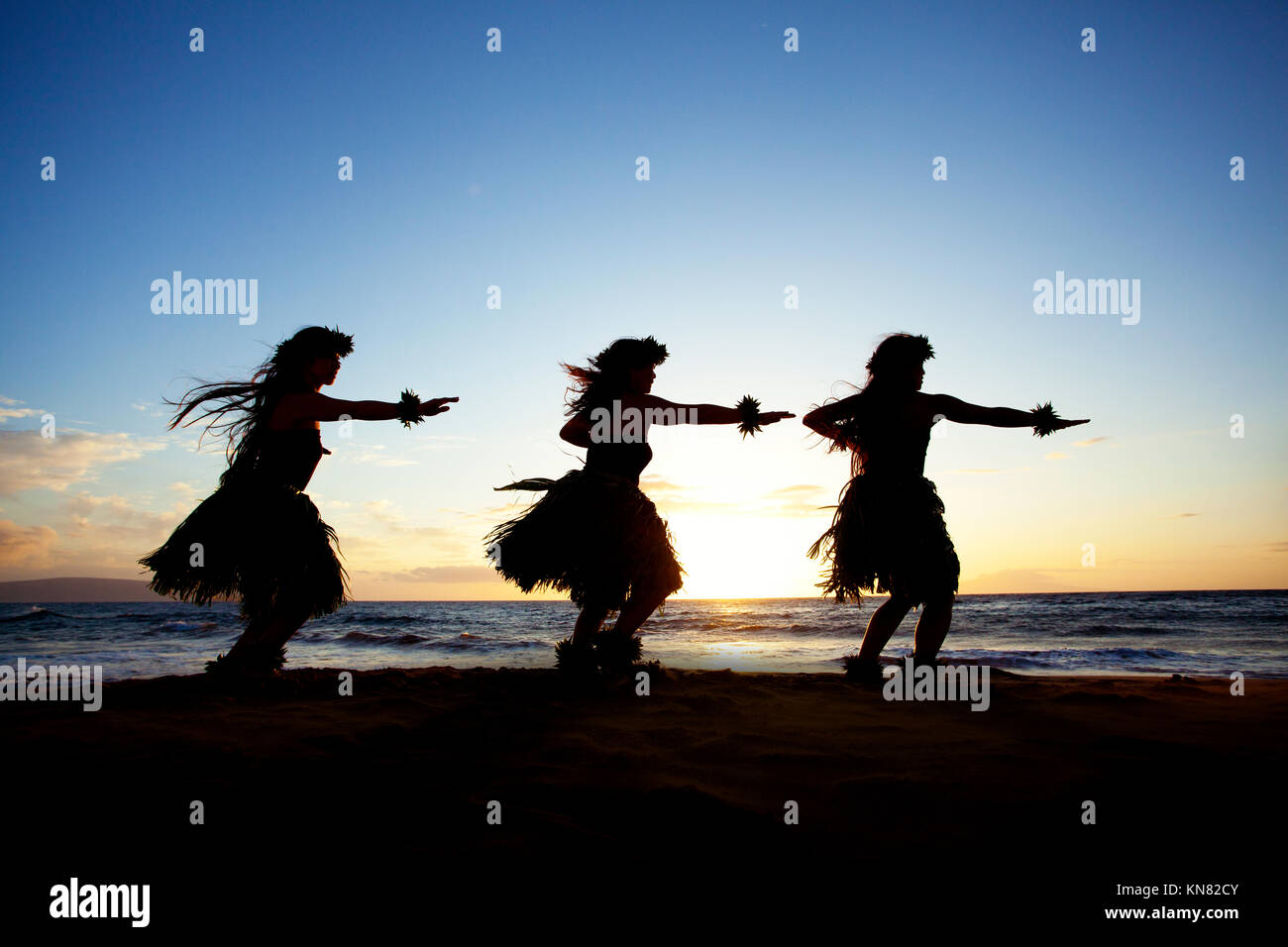 Trois danseurs hula au coucher du soleil à Wailea, Maui, Hawaï. Banque D'Images