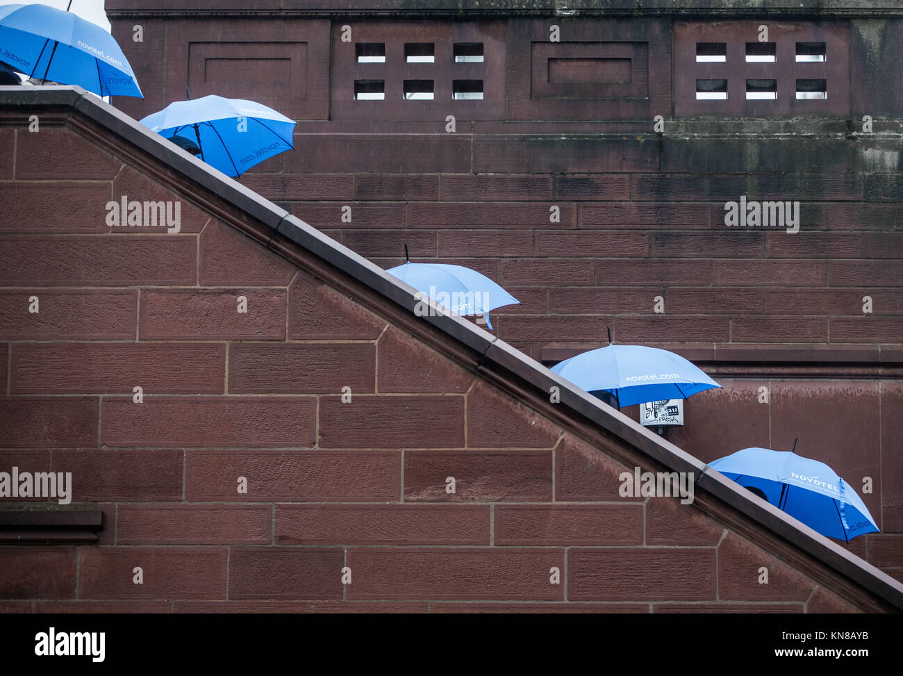 Un groupe de touristes d'Asie marche dans l'escalier de l'Eiserner Steg pont blue parasols à Francfort/Main, Allemagne, 11 décembre 2017. Photo : Frank Rumpenhorst/dpa Banque D'Images