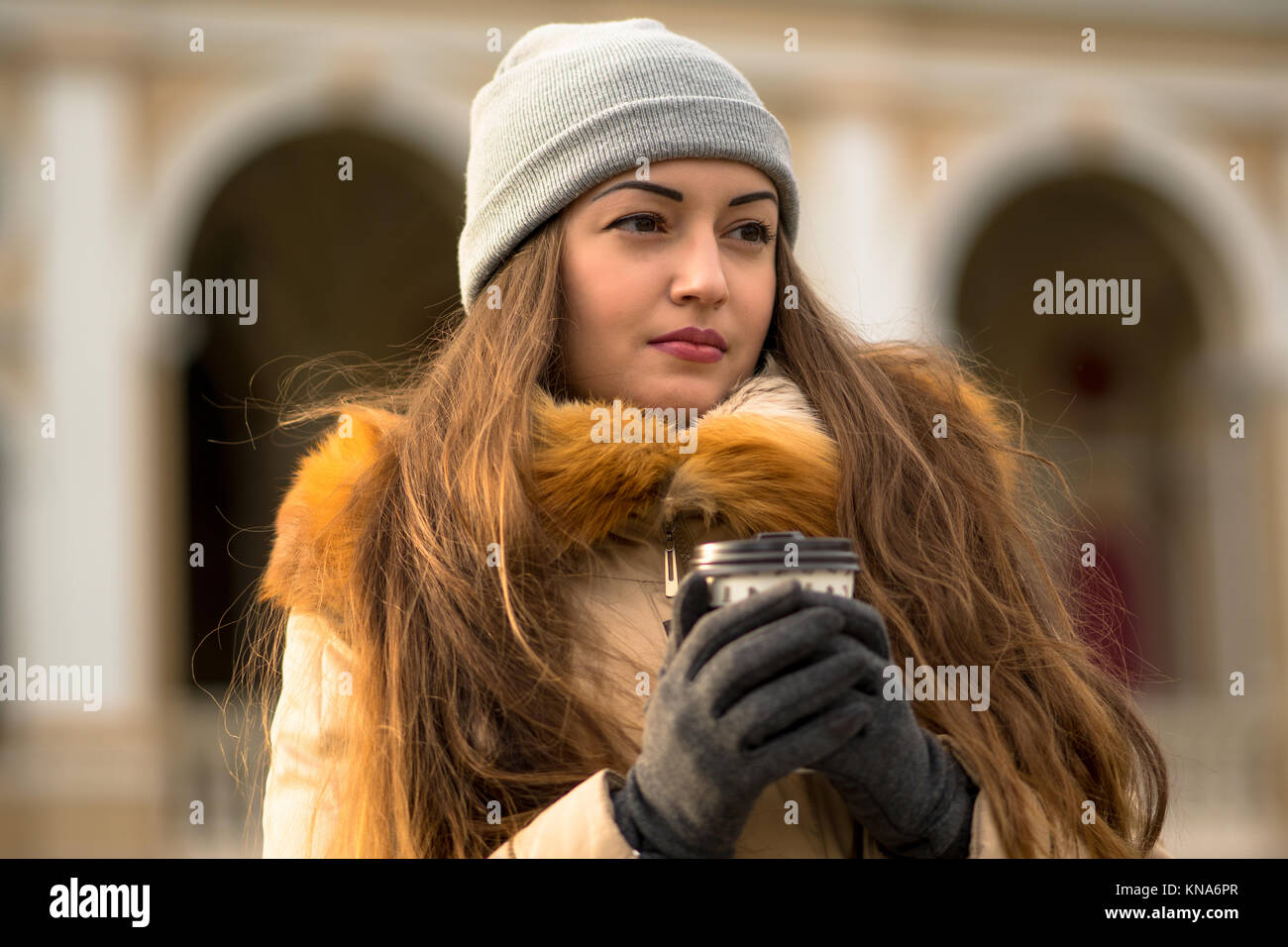 Cheerful young woman walking on the street et de boire du café Banque D'Images