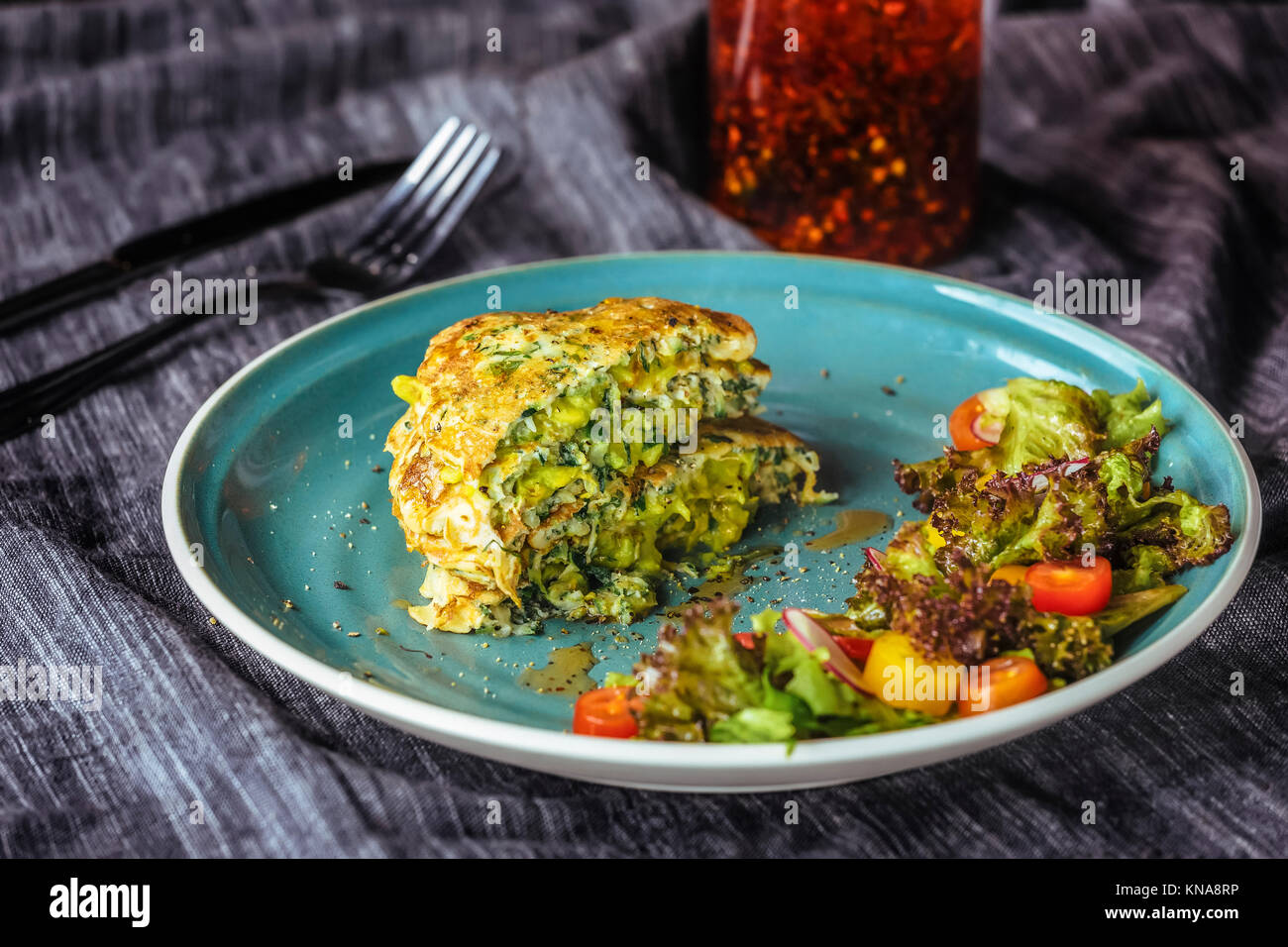 Crêpes de courgettes avec de la salade à l'assiette bleue Banque D'Images