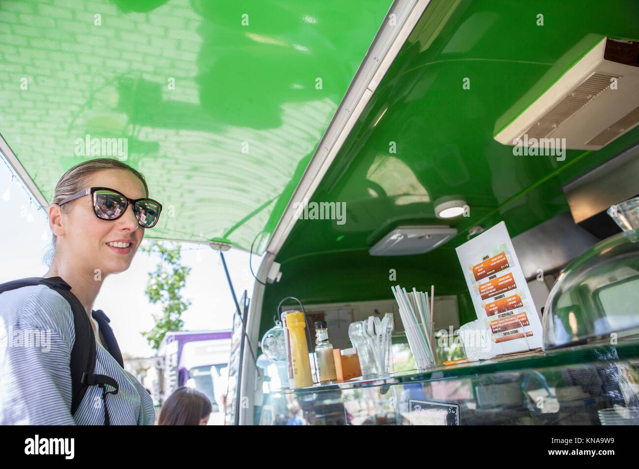 Merida, Espagne - 14 mai 2017 : Jeune femme attrative repas dans commande green food truck, dans la ville historique de Merida, Estrémadure, Espagne. Banque D'Images