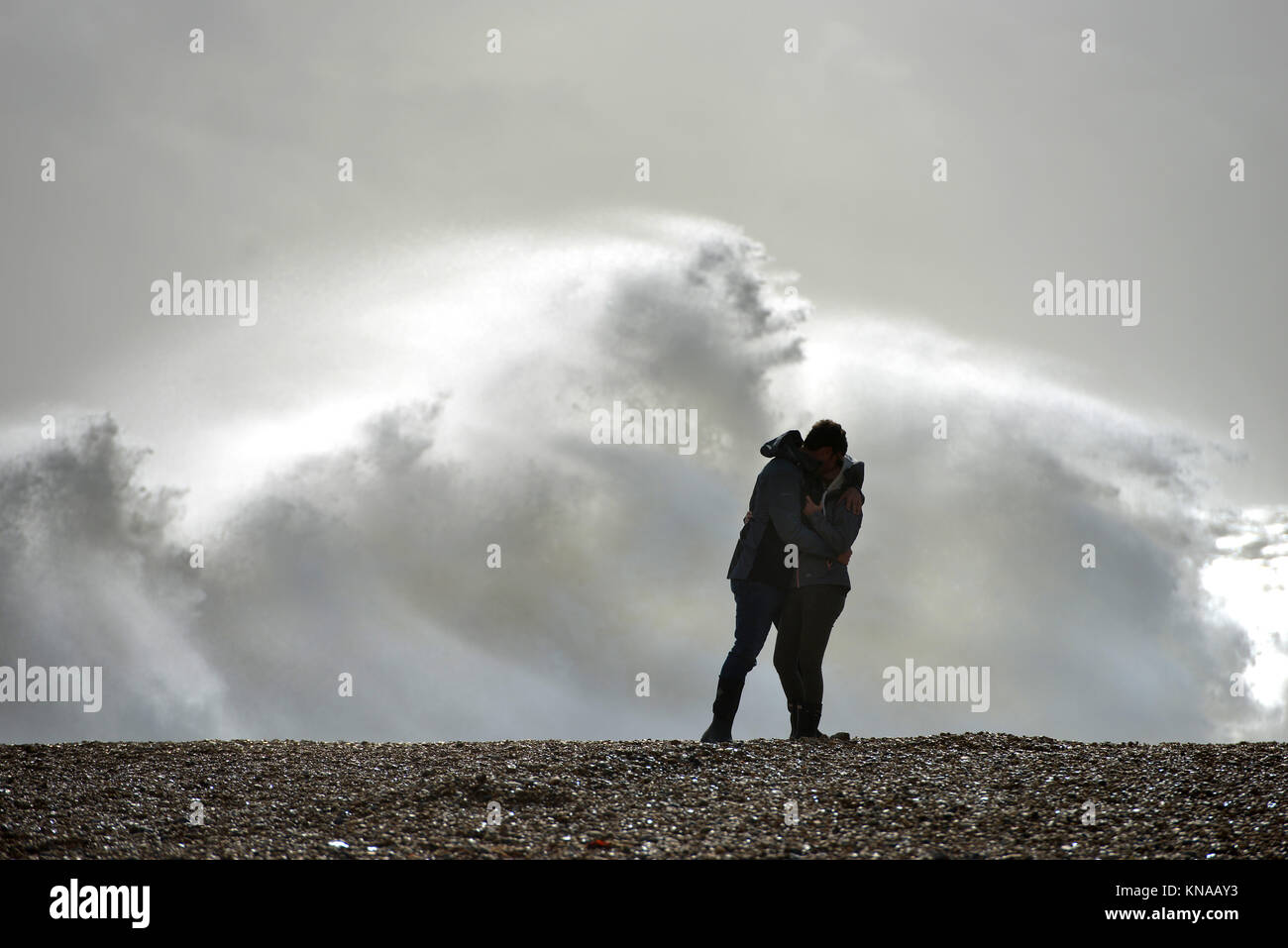 Couple sur une plage avec une mer agitée Banque D'Images