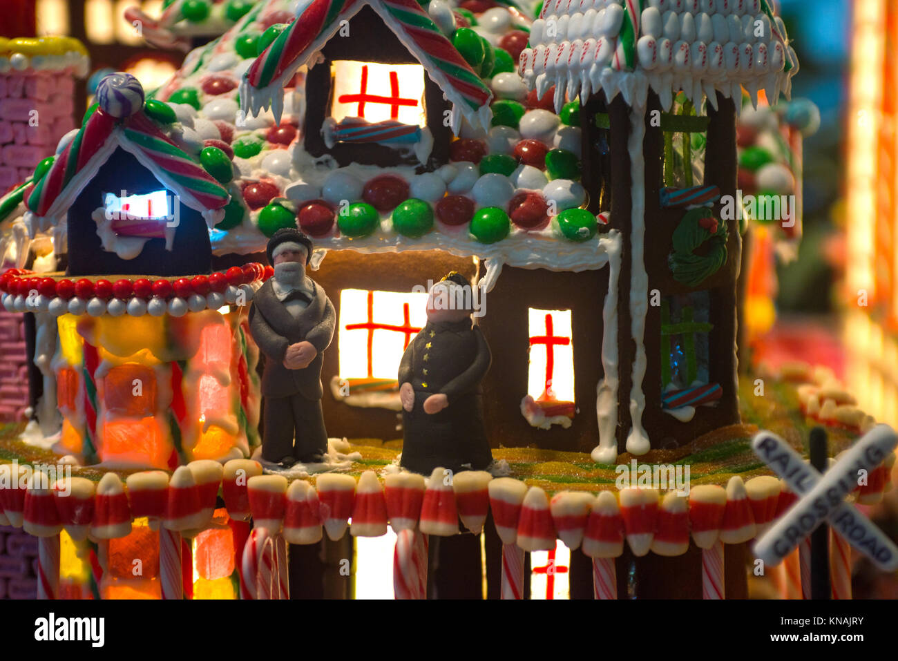 Détails artistiques de gingerbread village avec éclairage intérieur brille à travers les fenêtres et un vieux couple homme et femme se tenir dans la cour jusqu'à la Banque D'Images