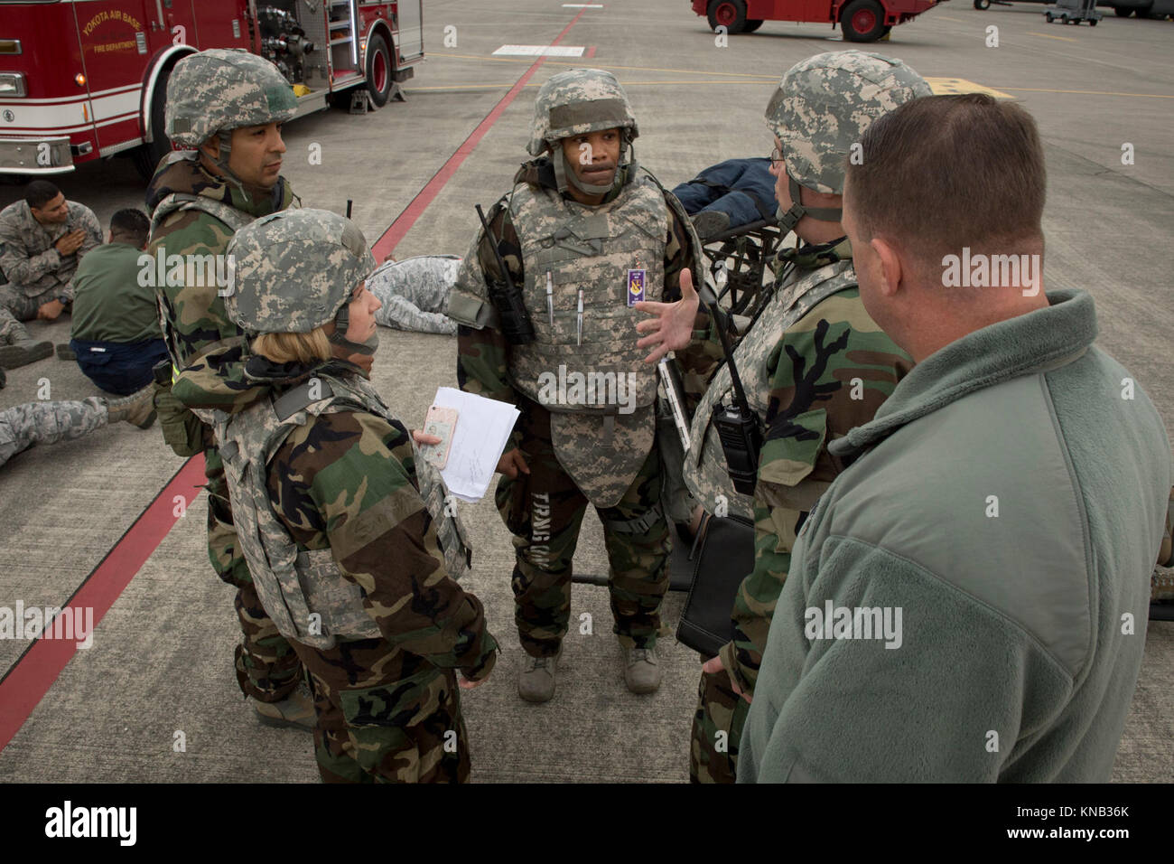 Les membres de l'équipe d'inspection d'aile de discuter de l'issue de l'intervention d'urgence d'une simulation d'attaque de missiles sur la ligne de vol pendant l'exercice Beverly matin 17-08 en liaison avec l'exercice Vigilant Ace 18, 4 décembre 2017, à Yokota Air Base, le Japon. L'esprit d'évaluer divers scénarios d'exercice pour assurer le réalisme et repérer les lacunes dans les procédures d'urgence pour des situations différentes. (U.S. Air Force Banque D'Images