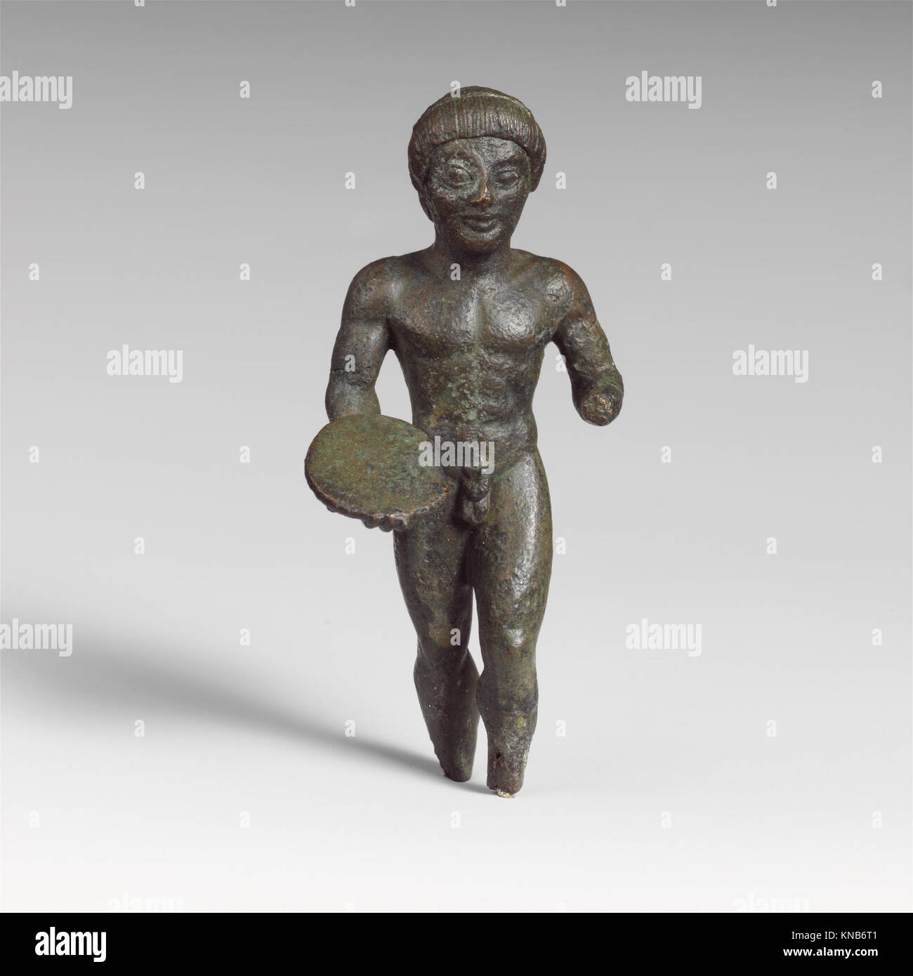 Statuette étrusque en bronze d'un lanceur de disques du Ve siècle av. J.-C., mettant en valeur la forme athlétique et l'artisanat dans le style grec Banque D'Images