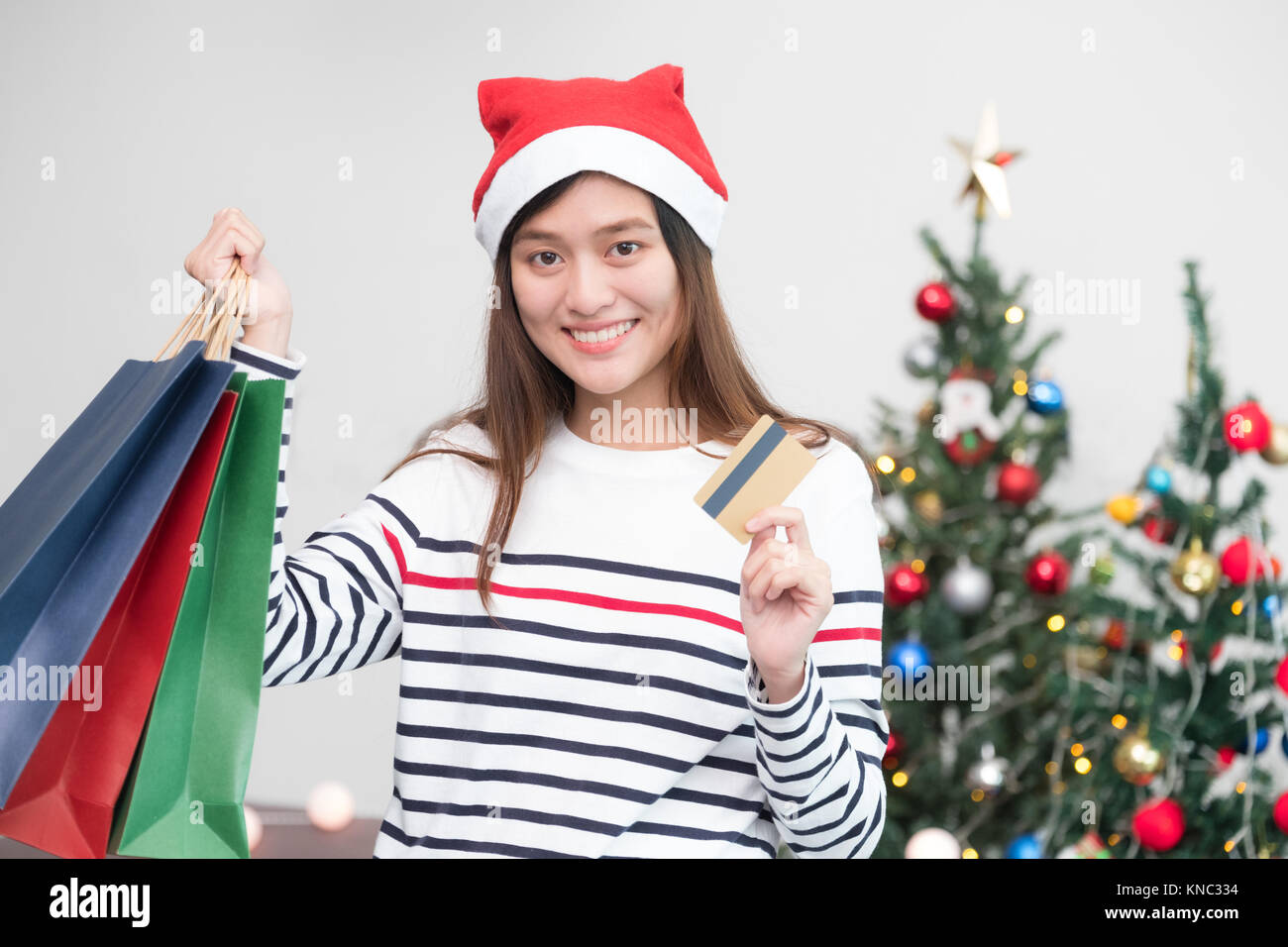 Professionnels de l'Asie utilisation femme carte de crédit achat de cadeaux de Noël panier à la partie,Maison de magasinage en ligne Banque D'Images